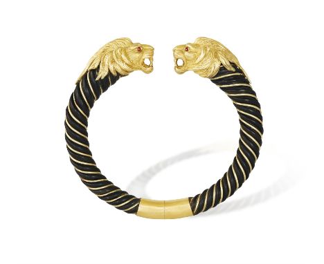 A RUBY AND GOLD  BANGLE, BY GAY FRÈRES, CIRCA 1970Each terminal modelled as a lion's head with circular-cut ruby eyes, the ba