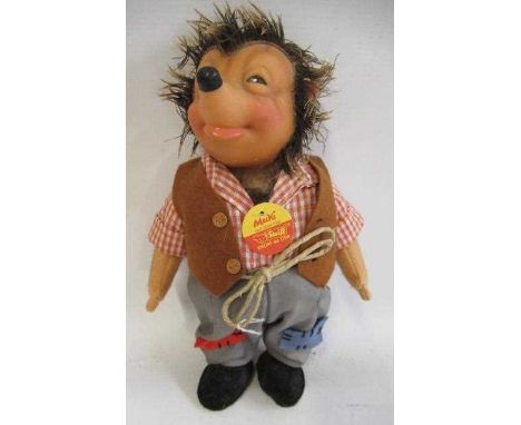 A Steiff Mecki, with celluloid face, felt arms, clothing, brass button, label and card tag, 25cm tall (Est. plus 24% premium 