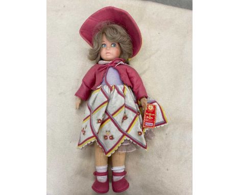 A Lenci girl doll, with felt face and body, painted features, real hair, original outfit, bonnet and card label, 20" long (Es