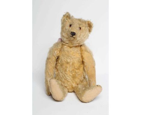 An early Steiff teddy bear, with amber glass eyes, sewn nose, felt pads, orange plush and button to ear, 16" long (Est. plus 