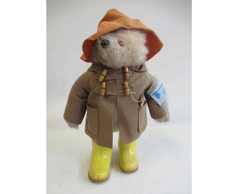 A Gabrielle Designs Paddington Bear, with amber eyes, orange felt hat, brown jacket, yellow Dunlop boots and card label, 18" 