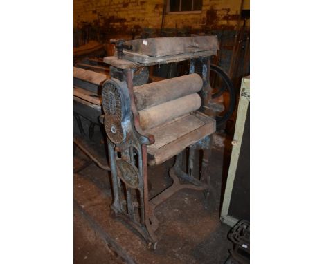 A cast iron and wooden vintage mangle, the frame cast with a trademark symbol of a phoenix rising from the ashes, height 127c