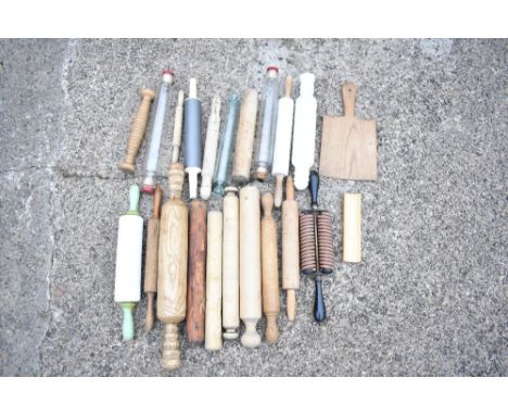 A collection of sixteen vintage treen, glass, marble, and plastic rolling pins, also an ash kitchen paddle, an ash oven paddl