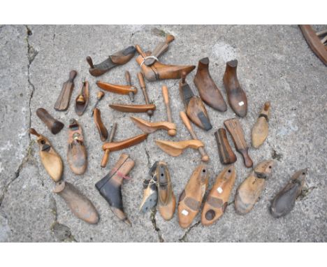 A collection of twenty-seven vintage treen shoe lasts and shoe moulds, including a pair with leather mounts, with various ins