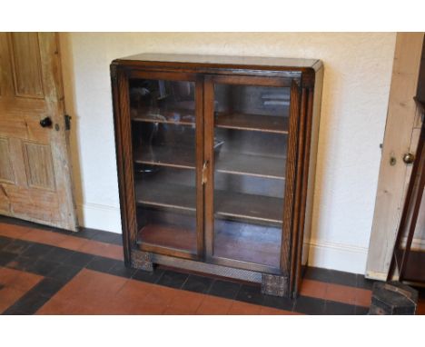 A 1930s Continental Art Deco oak two door display cabinet, on bracket feet, height 119cm, width 102cm, depth 36cm.PROVENANCE: