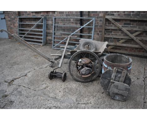 A vintage pine wheelbarrow, a wooden barrow wheel, an iron and rubber example, a push-along lawnmower, a motorcycle wheel and