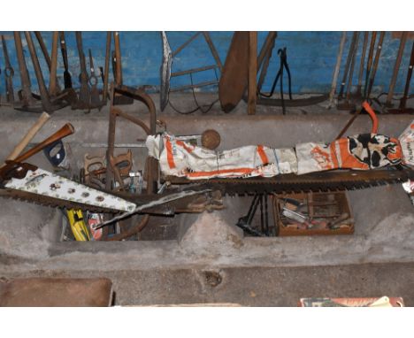 A large assortment of vintage saws, including three twin handled saws, the longest 164cm, and two hand saws with folk art dec