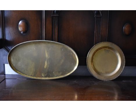 HUGH WALLACE; two brass dishes, one circular, diameter 28.5cm, and one oval, length 52cm, both stamped (2).PROVENANCE: The Ra