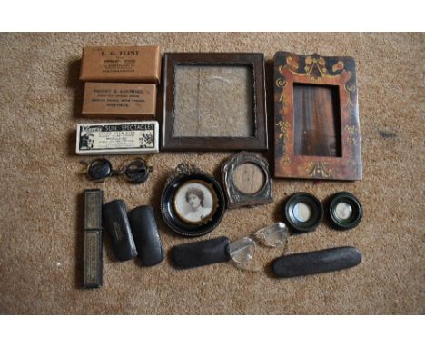 A small selection of vintage spectacles, some in original boxes which are named, an Art Nouveau copper mounted oak photograph
