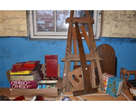 A wooden shove ha'penny board, two wooden children's artist easels, and a selection of vintage games. PROVENANCE: The Raymond