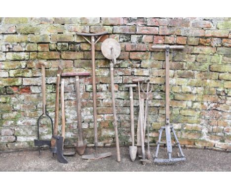A collection of twelve late 19th century and later vintage agricultural farm tools, including a six prong hoe, a brummock axe