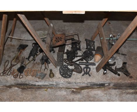 A collection of wrought and cast iron fireside items including eight teapot stands, also three cast iron clock numerals, and 