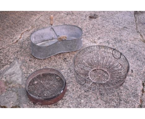 A vintage galvanised kidney shaped seed drill container, length 59.5cm, also two iron soil sieves and a circular garden plant