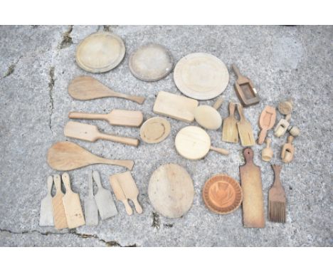 A selection of treen butter production items, including ten butter pats, seven butter prints, a turned wooden disc shaped mou