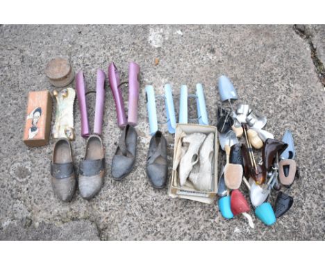 A selection of plastic and metal shoe stretchers, also a pair of leather mounted carved wood clogs, and a pair of lady's even