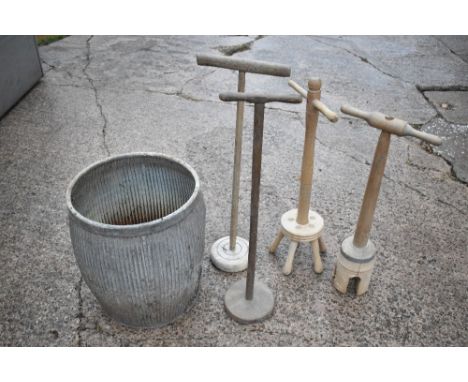 A galvanised wash tub, height 51cm, and four wooden wash dollies (5).PROVENANCE: The Raymond Rush Collection. Mr Rush was an 