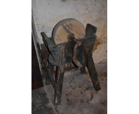 A vintage grinding wheel on green painted pine stand, height 95cm.PROVENANCE: The Raymond Rush Collection. Mr Rush was an eng