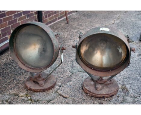 A pair of vintage cast iron searchlights/landing lights, the circular lights diameter 49.5cm, on gimballed supports and circu