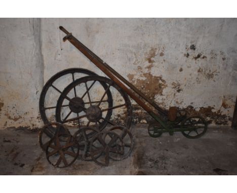 Two cast iron cartwheels, diameter 70cm, with five smaller wheels and two iron seed planters / drills.PROVENANCE: The Raymond