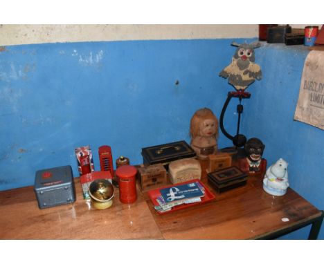 A selection of novelty and vintage money boxes including a cast iron money bank, a clog shaped treen money box, a coconut sha