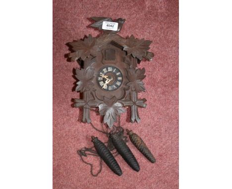 A Black Forest type cuckoo clock, with two cast iron acorn shaped weights, height 29cm.PROVENANCE: The Raymond Rush Collectio