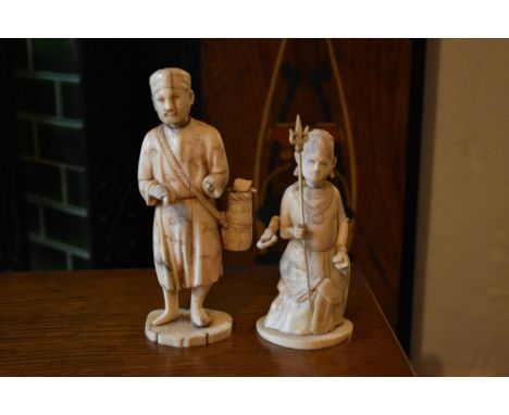 An early 20th century Japanese carved ivory figure of a gentleman pedlar, on oval base, and an early 20th century African car
