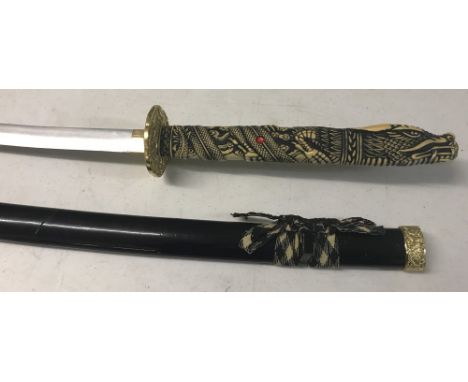 A modern oriental Samurai style sword with carved dragon design handle. In black lacquer scabbard (slight damage). Approx. 10