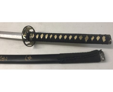 A modern oriental Samurai style sword with black fabric grip to handle. Wooden scabbard has carved detail to both sides. Cran