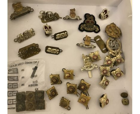A collection of military uniform and cap badges. To include "Tria Juncta in Uno" pips and Royal Army Pay Corps badges. 