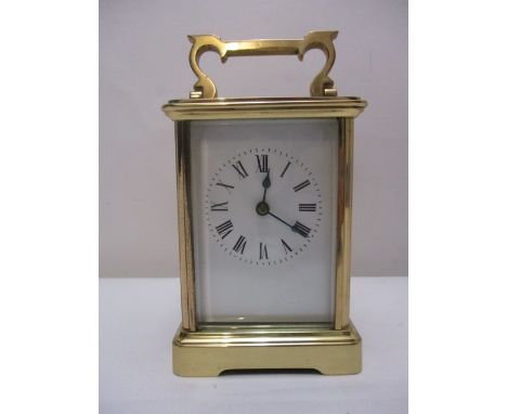 A mid 20th century brass carriage clock, time piece with a folding top handle, visible cylinder escapement, over four glass p