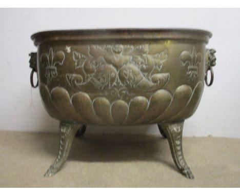A 20th century brass jardinière with embossed fruit, gadrooned and fleur de lys decoration and twin lion mask, ring handles, 