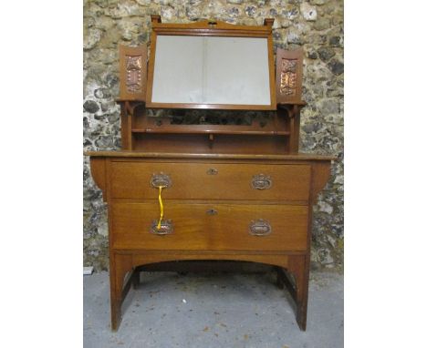 An Arts & Crafts oak dressing table attributed to Shapland & Petter of Barnstable, Devon, having a swing mirror pivoting on p