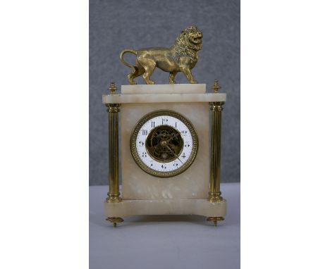 A 19th century alabaster and gilt spelter mantle clock. Lion to the top and exposed skeleton movement to the centre of the di