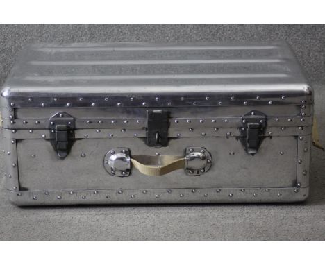 A vintage polished aluminium aviation trunk. With iron fittings, studded detailing and canvas handle. H.34 W.80 D.50 cm. 