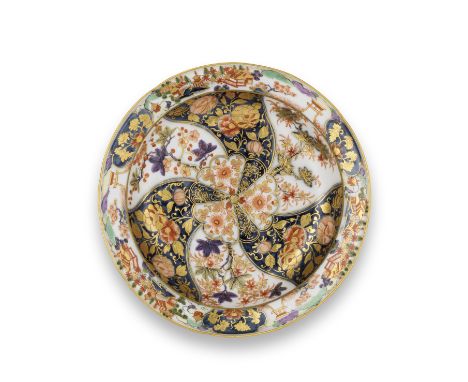 A Meissen deep plate, circa 1765Painted in underglaze-blue, enamels and gilding with a central flower motif with radiating pa