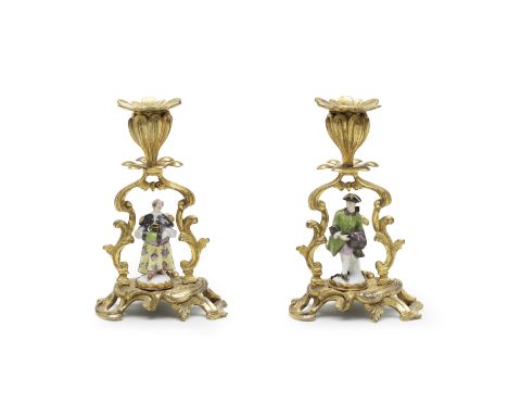 A pair of ormolu candlesticks mounted with miniature Meissen figures, the porcelain mid-18th centuryModelled as a lady and ge