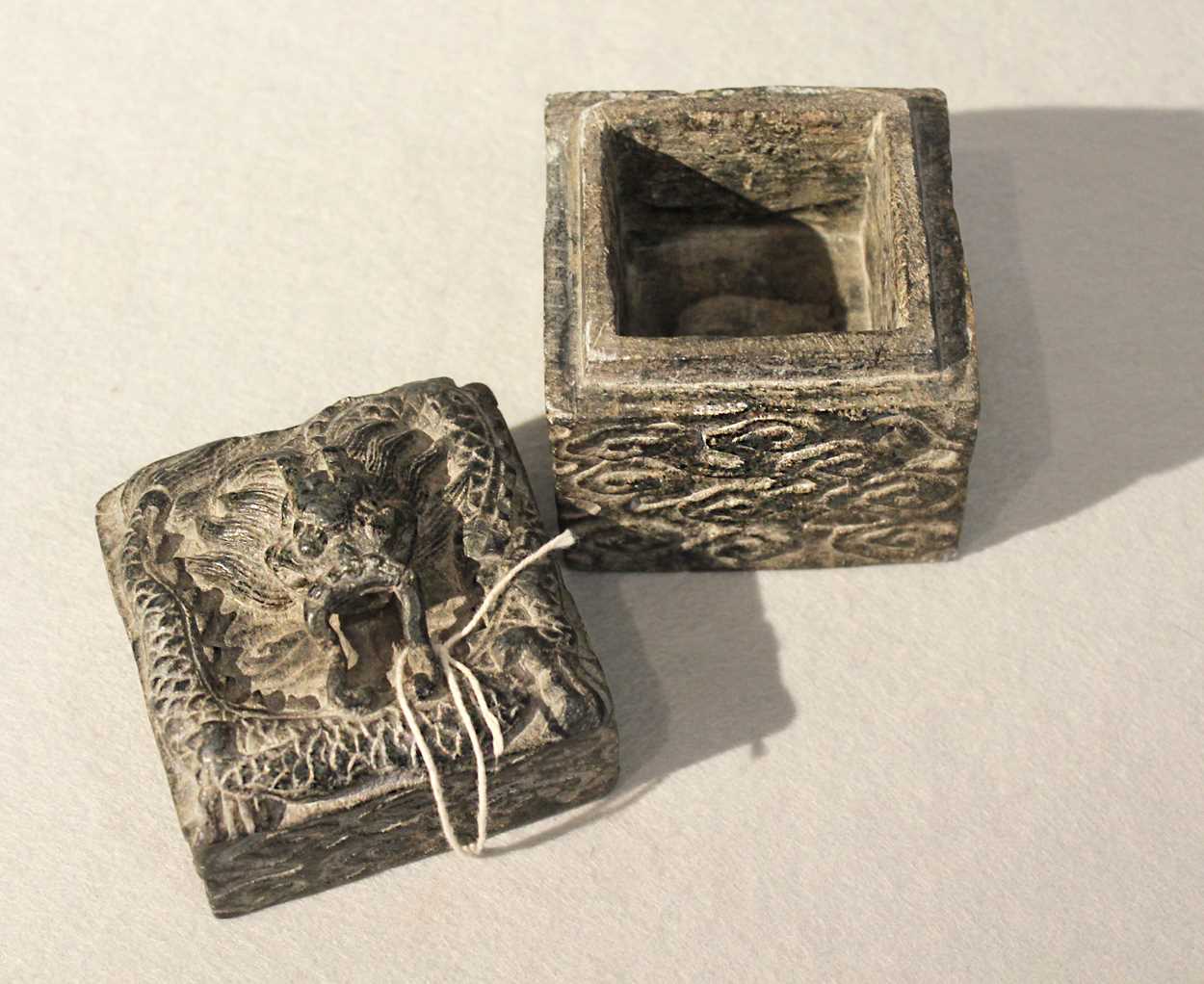 A group of three Chinese decorative stone boxes and a relief carved