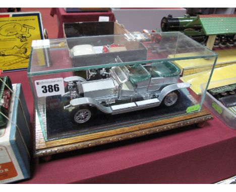 A Franklin Mint Rolls Royce Silver Ghost, highly detailed diecast scale model, mounted on a wooden plinth with glass display 