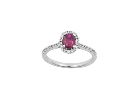 An 18 Carat White Gold Ruby and Diamond Cluster Ringthe oval cut ruby within a border of round brilliant cut diamonds, in cla