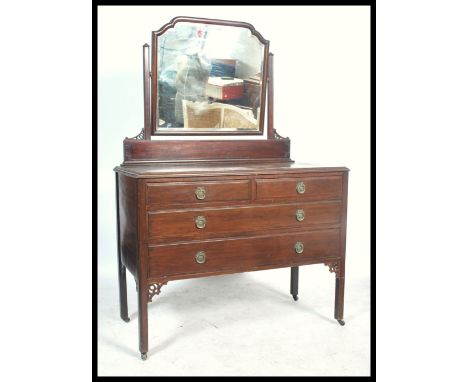 A vintage 20th century mahogany dressing table, fitted swing mirror over an arrangement of drawers. 157cm x 106cm x 52cm.