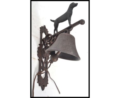 A vintage cast iron wall mounted bell in the form a standing black dog. Measures 35 cm high.