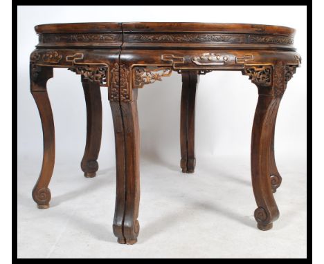 A large antique 20th century Chinese circular dining table from the Zhejiang province. The table made from two semi circles t