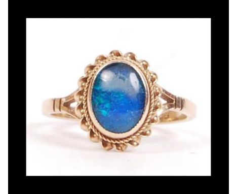 A hallmarked 9ct gold and opal style ring with a single opal doublet in a bezel setting. Hallmarked Birmingham. Weight 2.3g. 