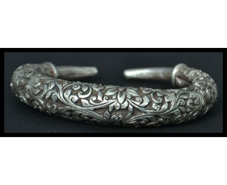 A Chinese silver bangle bracelet having an engraved foliage design. Weighs 47 grams.
