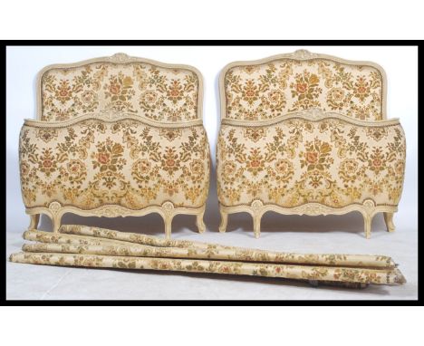 A pair of vintage 20th century French Single Corbeille beds having shabby chic painted head and footboards united by the rail