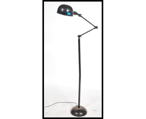 A retro mid century Industrial factory standard lamp raised on terraced base having tall adjustable arm with half moon enamel