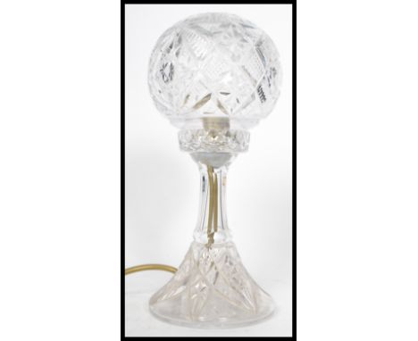 An early 20th century Edwardian cut glass table lamp. Raised on a trumpet base with faceted glass globe bulbous top. Measures