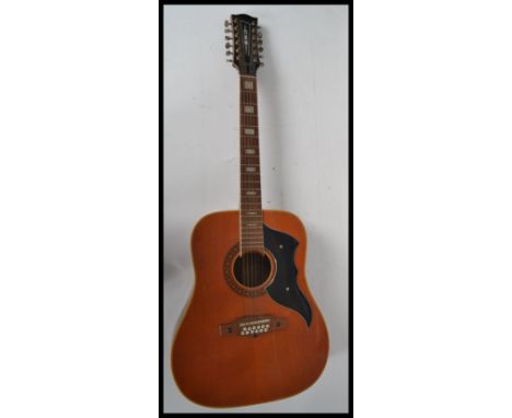A vintage Eko made 12 string acoustic guitar. The headstock with Eko plastic trim, and matching scratch plate. The soundhole 