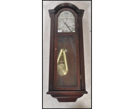 A 20th century wooden cased 31 day movement wall clock by Maxim. The silvered dial having a roman numeral chapter ring with f