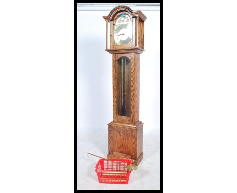 A 20th century oak cased Tempus Fugit longcase clock. The silvered dial with brass spandrels and roman numeral chapter ring. 